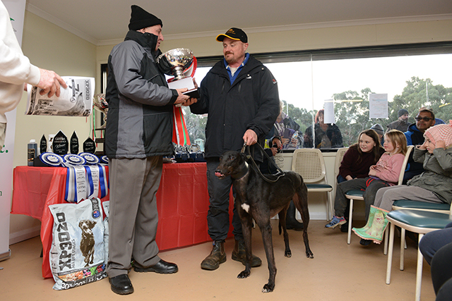 Greg Carter, President of Waterloo Cup sponsor the Cranbourne GRC, presents the winning trophy to trainer Ray Henness.