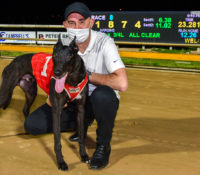 Typhoon Sammy and trainer Jason Thompson in front of the semaphore board after his track record run.