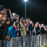 The crowd lines the fence on a cold Warrnambool night.